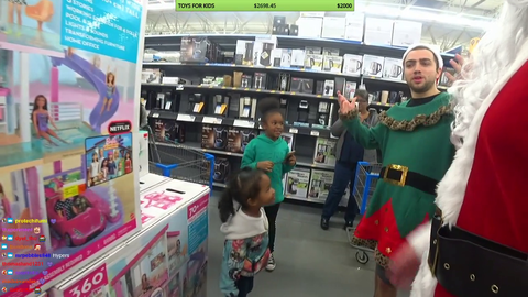 Santa and his elf give two girls an early christmas present
