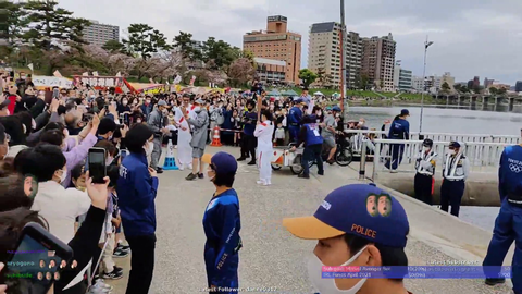 Tokyo 2020 Olympic torch being passed on.