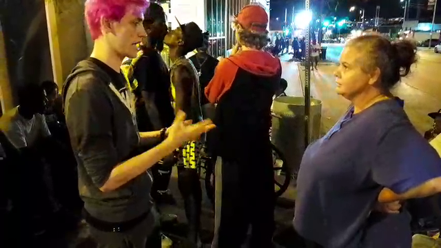Some homeless gay love in background during The Pink Twink performance